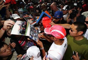 MELBOURNE, AUSTRALIA - MARCH 13:  Lewis Hamilton of Great Britain and McLaren Mercedes signs autographs for fans during previews for the Australian Formula One Grand Prix at the Albert Park Circuit on March 13, 2008 in Melbourne, Australia.  (Photo by Mark Thompson/Getty Images)