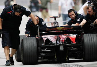 SAKHIR, BAHRAIN - APRIL 04:  Toro Rosso mechanics push the car of Sebastien Bourdais back into the team garage during practice for the Bahrain Formula One Grand Prix at the Bahrain International Circuit on April 4, 2008 in Sakhir, Bahrain.  (Photo by Peter Fox/Getty Images)