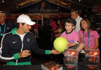 KEY BISCAYNE, FL - MARCH 25:  Roger Federer of Switzerland signs autographs for fans during day three of the Sony Ericsson Open at The Crandon Park Tennis Center on March 25, 2009 in Key Biscayne, Florida.  (Photo by Michael Heiman/Getty Images)