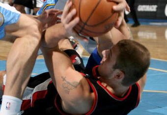 DENVER - MARCH 05:  Joel Przybilla #10 of the Portland Trail Blazers controls the ball while under pressure from Linas Kleiza #43 (L) and Chris Andersen #11 (R) of the Denver Nuggets during NBA action at the Pepsi Center on March 5, 2009 in Denver, Colorado. The Nuggets defeated the Trail Blazers 106-90. NOTE TO USER: User expressly acknowledges and agrees that, by downloading and/or using this Photograph, user is consenting to the terms and conditions of the Getty Images License Agreement.  (Photo by Doug Pensinger/Getty Images)