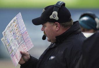 CHAMPAIGN, IL-NOVEMBER 3:  Andy Reid Head Coach of the Philadelphia Eagles reads the game plan against the Chicago Bears during the NFL game on November 3, 2002 at Memorial Stadium at the University of Illinois in Champaign, Illinois.  The Eagles defeated the Bears 19-13. (Photo by Jonathan Daniel/Getty Images)