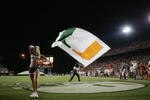 MIAMI - OCTOBER 14:  A male Miami Hurricanes cheerleader waves a giant flag while a female cheerleader performs during the game against the Florida International Panthers at the Orange Bowl on October 14, 2006 in Miami, Florida. Miami won 35-0.  (Photo by Marc Serota/Getty Images)