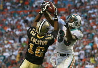 MIAMI - OCTOBER 25:  Cornerback Nathan Jones #33 of the Miami Dolphins takes a pass away from wide receiver Marques Colston #12 of the New Orleans Saints at Land Shark Stadium on October 25, 2009 in Miami, Florida. The Saints defeated the Dolphins 46-34.  (Photo by Doug Benc/Getty Images)