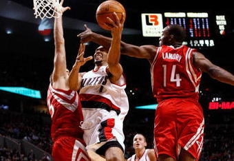 PORTLAND, OR - OCTOBER 27:  Brandon Roy #7 of the Portland Trail Blazers drives against Carl Landry #14 and David Andersen #13 of the Houston Rockets during the season opener on October 27, 2009 at the Rose Garden in Portland, Oregon. NOTE TO USER: User expressly acknowledges and agrees that, by downloading and or using this Photograph, user is consenting to the terms and conditions of the Getty Images License Agreement.  (Photo by Jonathan Ferrey/Getty Images)