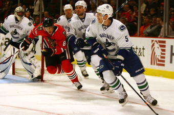 CHICAGO - OCTOBER 21: Christian Ehrhoff #5 of the Vancouver Canucks looks to pass as Tomas Kopecky #82 of the Chicago Blackhawks skates in pursuit at the United Center on October 14, 2009 in Chicago, Illinois. (Photo by Jonathan Daniel/Getty Images)