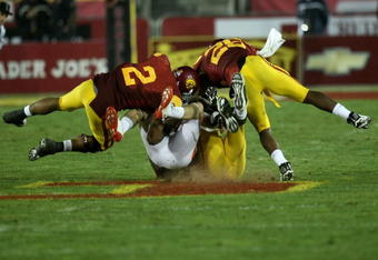 LOS ANGELES - OCTOBER 24:  Safeties Taylor Mays #2 and Will Harris #26 of the USC Trojans tackle Casey Kjos #25 of the Oregon State Beavers on October 24, 2009 at the Los Angeles Coliseum in Los Angeles, California.   USC won 42-36.  (Photo by Stephen Dunn/Getty Images)