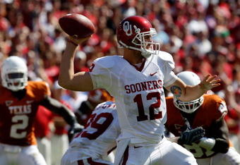 DALLAS - OCTOBER 17:  Quarterback Landry Jones #12 of the Oklahoma Sooners drops back to pass against the Texas Longhorns at Cotton Bowl on October 17, 2009 in Dallas, Texas.  (Photo by Ronald Martinez/Getty Images)