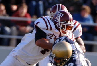 ANNAPOLIS, MD - NOVEMBER 19:  In this handout from the U.S. Navy, U.S. Naval Academy Midshipman full back Adam Ballard #22 is tackled by Temple Owls defender Justin Johnson #4 during the 1st quarter of play on November 19, 2005 at Navy Memorial Stadium in Annapolis, Maryland.  (Photo by Damon J. Moritz/U.S. Navy via Getty Images)