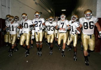 LOS ANGELES, CA - NOVEMBER 29:  Quarterback Jimmy Clausen #7 of the Notre Dame Fighting Irish walks out with teammates Robert Hughes #33 and Sergio Brown #31 before the game against the USC Trojans at Los Angeles Memorial Coliseum on November 29, 2008 in Los Angeles, California. The Trojans defeated the Fighting Irish 38-3.  (Photo by Christian Petersen/Getty Images)