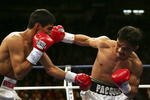 LAS VEGAS - NOVEMBER 18:  (R-L) Manny Pacquiao of the Philippines connects with a right to the face of Erik Morales of Mexico during their super featherweight bout at the Thomas & Mack Center on November 18, 2006 in Las Vegas, Nevada. Pacquiao won after a third round knockout.  (Photo by Jed Jacobsohn/Getty Images)