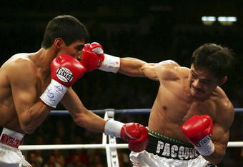 LAS VEGAS - NOVEMBER 18:  (R-L) Manny Pacquiao of the Philippines connects with a right to the face of Erik Morales of Mexico during their super featherweight bout at the Thomas & Mack Center on November 18, 2006 in Las Vegas, Nevada. Pacquiao won after a third round knockout.  (Photo by Jed Jacobsohn/Getty Images)