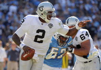 SAN DIEGO - NOVEMBER 01:  JaMarcus Russell #2 of the Oakland Raiders scrambles out of the pocket as he is rushed by Larry Engllish #52 of the San Diego Chargers during the second quarter at Qualcomm Stadium on November 1, 2009 in San Diego California.  (Photo by Harry How/Getty Images)