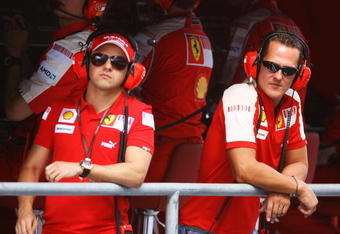 ABU DHABI, UNITED ARAB EMIRATES - OCTOBER 30:  Former Ferrari F1 World Champion Michael Schmumacher (R) of Germany talks with Felipe Massa (L) of Brazil and Ferrari on the pitwall during practice for the Abu Dhabi Formula One Grand Prix at the Yas Marina Circuit on October 30, 2009 in Abu Dhabi, United Arab Emirates.  (Photo by Paul Gilham/Getty Images)