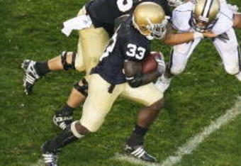SOUTH BEND, IN - OCTOBER 03: Robert Hughes #33 of the Notre Dame Fighting Irish gains yardage against the Washington Huskies on October 3, 2009 at Notre Dame Stadium in South Bend, Indiana. Notre Dame defeated Washington 37-30 in overtime. (Photo by Jonathan Daniel/Getty Images)