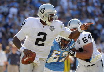 SAN DIEGO - NOVEMBER 01:  JaMarcus Russell #2 of the Oakland Raiders scrambles out of the pocket as he is rushed by Larry Engllish #52 of the San Diego Chargers during the second quarter at Qualcomm Stadium on November 1, 2009 in San Diego California.  (Photo by Harry How/Getty Images)