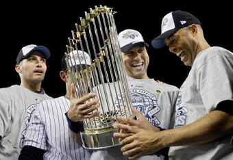 NEW YORK - NOVEMBER 04:  (L-R) Andy Pettitte #46, Jorge Posada #20, Derek Jeter #2 and Mariano Rivera #42 of the New York Yankees celebrate with the trophy after their 7-3 win against the Philadelphia Phillies in Game Six of the 2009 MLB World Series at Yankee Stadium on November 4, 2009 in the Bronx borough of New York City.  (Photo by Pool/Getty Images)