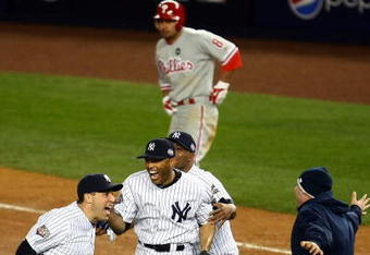 NEW YORK - NOVEMBER 04:  Mark Teixeira (L) and Mariano Rivera (C) of the New York Yankees celebrate their 7-3 win as Shane Victorino #8 of the Philadelphia Phillies walks off the field dejected in Game Six of the 2009 MLB World Series at Yankee Stadium on November 4, 2009 in the Bronx borough of New York City.  (Photo by Chris McGrath/Getty Images)