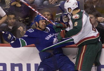 VANCOUVER, CANADA - OCTOBER 17: Darcy Hordichuk #24 of the Vancouver Canucks reacts after getting hit by Brent Burns #8 of the Minnesota Wild during the third period of NHL action on October 17, 2009 at General Motors Place in Vancouver, British Columbia, Canada.  (Photo by Rich Lam/Getty Images)