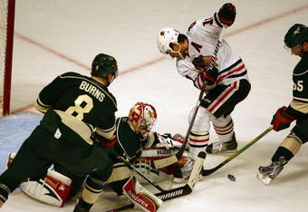 CHICAGO - OCTOBER 26: Niklas Backstrom #32 of the Minnesota Wild falls to knock the puck away from Patrick Sharp #10 of the Chicago Blackhawks as Brent Burns #8 and Nick Schultz #55 defend at the United Center on October 26, 2009 in Chicago, Illinois. The Blackhawks defeated the Wild 3-1. (Photo by Jonathan Daniel/Getty Images)