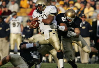 SOUTH BEND, IN - NOVEMBER 12: Quarterback Brian Hampton #3 of the Navy Midshipman is hit by linebackers Anthony Vernaglia #4, Joe Brockington #52 and Nick Borseti #56 of the Notre Dame Fighting Irish on November 12, 2005 at Notre Dame Stadium in South Bend, Indiana. Notre Dame defeated Navy 42-21. (Photo by Jonathan Daniel/Getty Images)