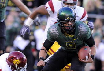 EUGENE, OR - OCTOBER 31: Quarterback Jeremiah Masoli #8 of the Oregon Ducks breaks a tackle of linebacker Malcolm Smith #6 as he heads to the end zone in the first quarter of the game against the USC Trojans at Autzen Stadium on October 31, 2009 in Eugene, Oregon. Masoli threw for 222 yards and a touchdown and ran for 164 more yards with another score as Oregon defeated USC 47-20. (Photo by Steve Dykes/Getty Images)