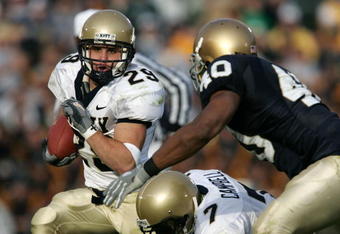 SOUTH BEND, IN - NOVEMBER 12:  Marco Nelson #29 of the Navy Midshipman runs for yardage as teammate Reggie Campbell #7 blocks Maurice Crum #40 of the Notre Dame Fighting Irish on November 12, 2005 at Notre Dame Stadium in South Bend, Indiana. Notre Dame defeated Navy 42-21.  (Photo by Jonathan Daniel/Getty Images)