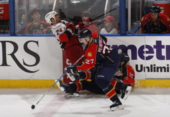 SUNRISE, FL - NOVEMBER 4: Steven Reinprecht #27 skates away with the puck as Nathan Horton #16 of the Florida Panthers checks Scott Walker #24 of the Carolina Hurricanes in the third period on November 4, 2009 at the BankAtlantic Center in Sunrise, Florida. The Panthers defeated the Hurricanes 3-0. (Photo by Joel Auerbach/Getty Images)