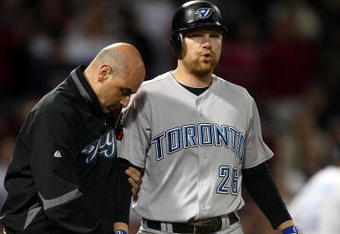 BOSTON - SEPTEMBER 29:  Adam Lind #26 of the Toronto Blue Jays is looked after by a member of the medical staff after he was hit by a pitch in the ninth inning against the Boston Red Sox on September 29, 2009 at Fenway Park in Boston, Massachusetts. The Blue Jays defeated the Red Sox 8-7.  (Photo by Elsa/Getty Images)