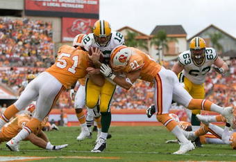 TAMPA, FL - NOVEMBER 08:  Quarterback Aaron Rodgers #12 of the Green Bay Packers scores a fourth quarter touchdown as defenders Barrett Ruud #51 and Sabby Piscatelli #21 of the Tampa Bay Buccaneers deliver a hit during the game at Raymond James Stadium on November 8, 2009 in Tampa, Florida.  (Photo by J. Meric/Getty Images)