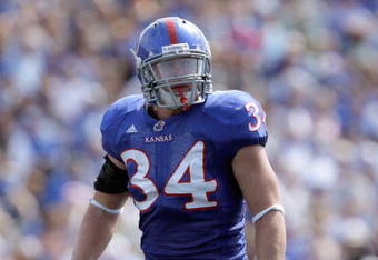 LAWRENCE, KS - SEPTEMBER 19:  Linebacker Huldon Tharp #34 of the Kansas Jayhawks gets ready on the line during the game against the Duke Blue Devils on Kivisto Field at Memorial Stadium on September 19, 2009 in Lawrence, Kansas. (Photo by Jamie Squire/Getty Images)