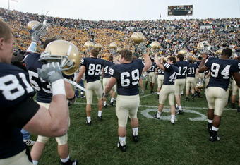 SOUTH BEND, IN - NOVEMBER 12:  Members of the Notre Dame Fighting Irish inclduing Rob Woods #81, Neil Kennedy #69 and Justin Brown #94 salute the students and fans following a game against the Navy Midshipman on November 12, 2005 at Notre Dame Stadium in South Bend, Indiana. Notre Dame defeated Navy 42-21. (Photo by Jonathan Daniel/Getty Images)