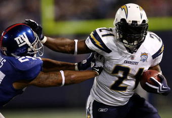 EAST RUTHERFORD, NJ - NOVEMBER 08:  LaDainian Tomlinson #21 of the San Diego Chargers fends off Terrell Thomas #24 of the the New York Giants on November 8, 2009 at Giants Stadium in East Rutherford, New Jersey.  (Photo by Chris McGrath/Getty Images)