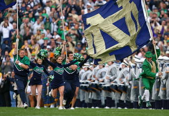 SOUTH BEND, IN - OCTOBER 03: Cheerleaders and the leprechaun mascot of the Notre Dame Fighting Irish run onto the field before a game against the Washington Huskies on October 3, 2009 at Notre Dame Stadium in South Bend, Indiana. Notre Dame defeated Washington 37-30in overtime. (Photo by Jonathan Daniel/Getty Images)