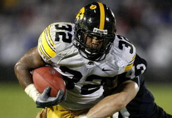 STATE COLLEGE, PA - SEPTEMBER 26:  Adam Robinson #32 of the Iowa Hawkeyes runs for a fourth quarter touchdown trough the tackle of Josh Hull #43 of the Penn State Nittnay Lions on September 26, 2009 at Beaver Stadium in State College, Pennsylvania. Iowa won the game 21-10. (Photo by Gregory Shamus/Getty Images)