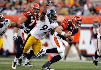CINCINNATI - SEPTEMBER 27:  Carson Palmer #9 of the Cincinnati Bengals runs with the ball while defended by James Harrison #92 of the Pittsburgh Steelers at Paul Brown Stadium on September 27, 2009 in Cincinnati, Ohio.  The Bengals won 23-20.  (Photo by Andy Lyons/Getty Images)