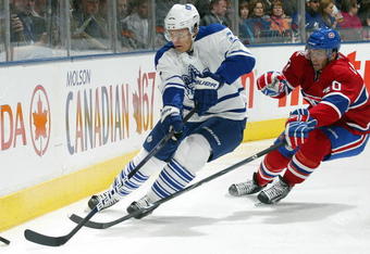 TORONTO - OCTOBER 1:  Luke Schenn #2 of the Toronto Maple Leafs clears the puck away from Maxim Lapierre #40 of the Montreal Canadiens in the Maple Leafs home opener on October 1, 2009 at the Air Canada Centre in Toronto, Ontario, Canada.  (Photo by Claus Andersen/Getty Images)