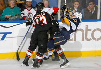 BUFFALO, NY - NOVEMBER 06: Dan Carcillo #13 of the Philadelphia Flyers checks Craig Rivet #52 of the Buffalo Sabres at HSBC Arena on November 6, 2009 in Buffalo, New York.  (Photo by Rick Stewart/Getty Images)