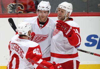 CALGARY, CANADA - OCTOBER 31: Kirk Maltby #18 of the Detroit Red Wings celebrates with teammates Daniel Cleary #18 and Henrik Zetterberg #40 during a break in game action against the Calgary Flames on October 31, 2009 at the Pengrowth Saddledome in Calgary, Alberta, Canada. The Red Wings defeated the Flames 3-1. (Photo by Dale MacMillan/Getty Images)