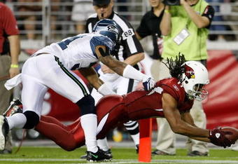 GLENDALE, AZ - NOVEMBER 15:  Larry Fitzgerald #11 of the Arizona Cardinals dives across the goal line for a touchdown while being pursued by Ken Lucas #31 of the Seattle Seahawks in the second half at University of Phoenix Stadium on November 15, 2009 in Glendale, Arizona. The Cardinals defeated the Seahawks 31-20.  (Photo by Jeff Gross/Getty Images)