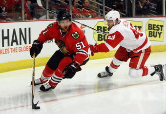 CHICAGO - MAY 22:  Brian Campbell #51 of the Chicago Blackhawks skates with the puck against Darren Helm #43 of the Detroit Red Wings during Game Three of the Western Conference Championship Round of the 2009 Stanley Cup Playoffs on May 22, 2009 at the United Center in Chicago, Illinois. The Blackhawks won 4-3 in overtime. (Photo by Jonathan Daniel/Getty Images)