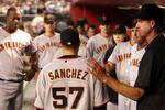 PHOENIX - JUNE 11:  Starting pitcher Jonathan Sanchez #57 of the San Francisco Giants is greeted by Randy Johnson (R) and teammates after being removed from the major league baseball game against the Arizona Diamondbacks at Chase Field on June 11, 2009 in Phoenix, Arizona.  The Diamondbacks defeated the Giants 2-1. (Photo by Christian Petersen/Getty Images)