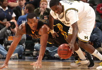 INDIANAPOLIS - MARCH 12:  Manny Harris #3 of the Michigan Wolveriens attempts to control a loose ball against Jarryd Cole #50 of the Iowa Hawkeyes during the first round of the Big Ten Men's Basketball Tournament at Conseco Fieldhouse on March 12, 2009 in Indianapolis, Indiana.  (Photo by Jonathan Daniel/Getty Images)