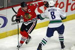 CHICAGO - OCTOBER 21: Jonathan Toews #19 of the Chicago Blackhawks controls for the puck against Willie Mitchell #8 of the Vancouver Canucks at the United Center on October 14, 2009 in Chicago, Illinois. The Canucks defeated the Blackhawks 3-2. (Photo by Jonathan Daniel/Getty Images)