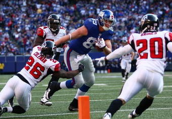 EAST RUTHERFORD, NJ - NOVEMBER 22:  Kevin Boss #89 of the the New York Giants fends off Erik Coleman #26 of the Atlanta Falcons to score a touchdown on November 22, 2009 at Giants Stadium in East Rutherford, New Jersey.  (Photo by Chris McGrath/Getty Images)