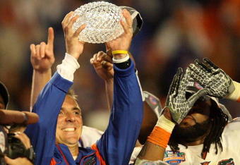 MIAMI - JANUARY 08:  Head coach Urban Meyer of the Florida Gators celebrates with the National Championship trophy after therir 24-14 win against the Oklahoma Sooners during the FedEx BCS National Championship game at Dolphin Stadium on January 8, 2009 in Miami, Florida.  (Photo by Doug Benc/Getty Images)