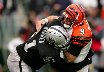 OAKLAND, CA - NOVEMBER 22:  Carson Palmer #9 of the Cincinnati Bengals is hit by Gerard Warren #61 of the Oakland Raiders at Oakland-Alameda County Coliseum on November 22, 2009 in Oakland, California.  (Photo by Ezra Shaw/Getty Images)