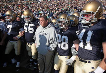 SOUTH BEND, IN - NOVEMBER 21: Head coach Charlie Weis of the Notre Dame Fighting Irish waits to enter the field with (L-R) Jimmy Clausen #7, Eric Olsen #55, Kyle McCarthy #28 and Scott Smith #41 before a game against the University of Connecticut Huskies at Notre Dame Stadium on November 21, 2009 in South Bend, Indiana. (Photo by Jonathan Daniel/Getty Images)