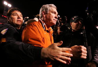 COLLEGE STATION, TX - NOVEMBER 23:  Head coach Mack Brown of the Texas Longhorns is escorted after a 38-30 loss to the Texas A&M Aggies at Kyle Field November 23, 2007 in College Station, Texas.  (Photo by Ronald Martinez/Getty Images)