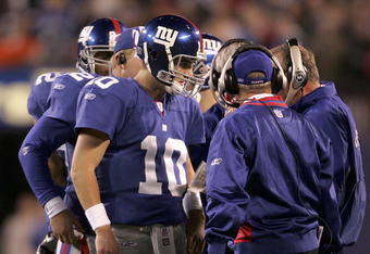 EAST RUTHERFORD, NJ - OCTOBER 23:  Quarterback Eli Manning #10 of the New York Giants talks with coaching staff during a time out before the last play of the game against the Denver Broncos on October 23, 2005 at Giants Stadium in East Rutherford, New Jersey. The Giants defeated the Broncos 24-23.  (Photo by Nick Laham/Getty Images)