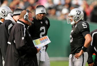 OAKLAND, CA - NOVEMBER 22:  Oakland Raiders head coach Tom Cable speaks to his new starting quarterback Bruce Gradkowski #5 while newly benched quarterback JaMarcus Russell #2 looks on during their game against the Cincinnati Bengals at Oakland-Alameda County Coliseum on November 22, 2009 in Oakland, California.  (Photo by Ezra Shaw/Getty Images)
